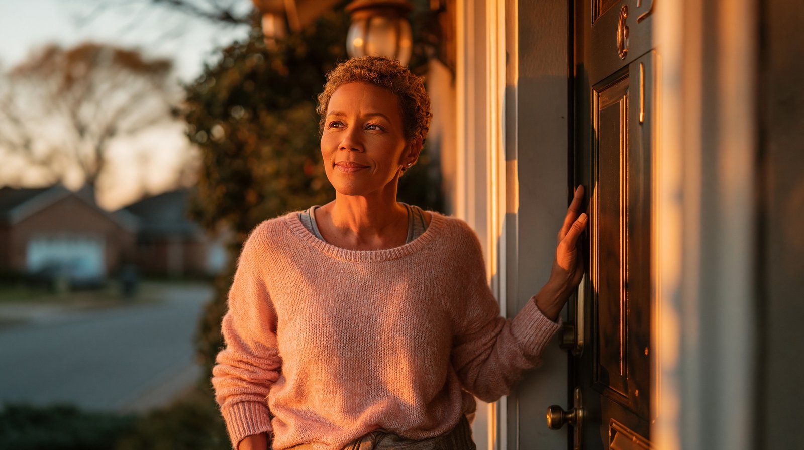 Adult woman over 55 stepping out her front door for a short morning walk as part of her daily movement habit after physical therapy.