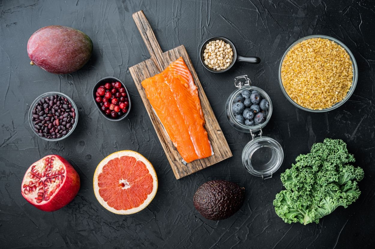 Flat lay of salmon, berries, walnuts, leafy greens, and olive oil representing the foods with the strongest evidence for knee health over 55.