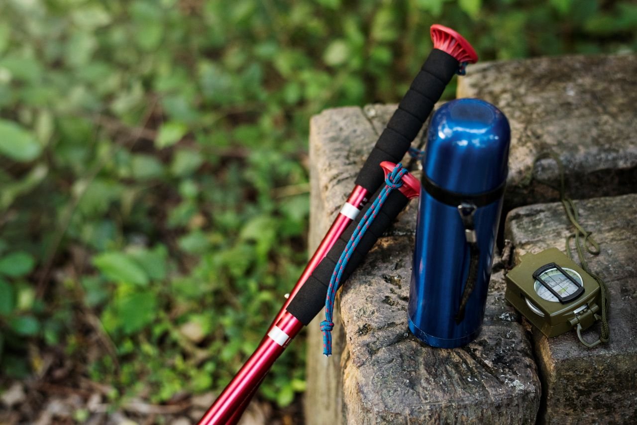 Walking poles planted at an angle on a paved path illustrating why the assumed pressure-reduction mechanism of poles for knee pain is more complicated than it seems.